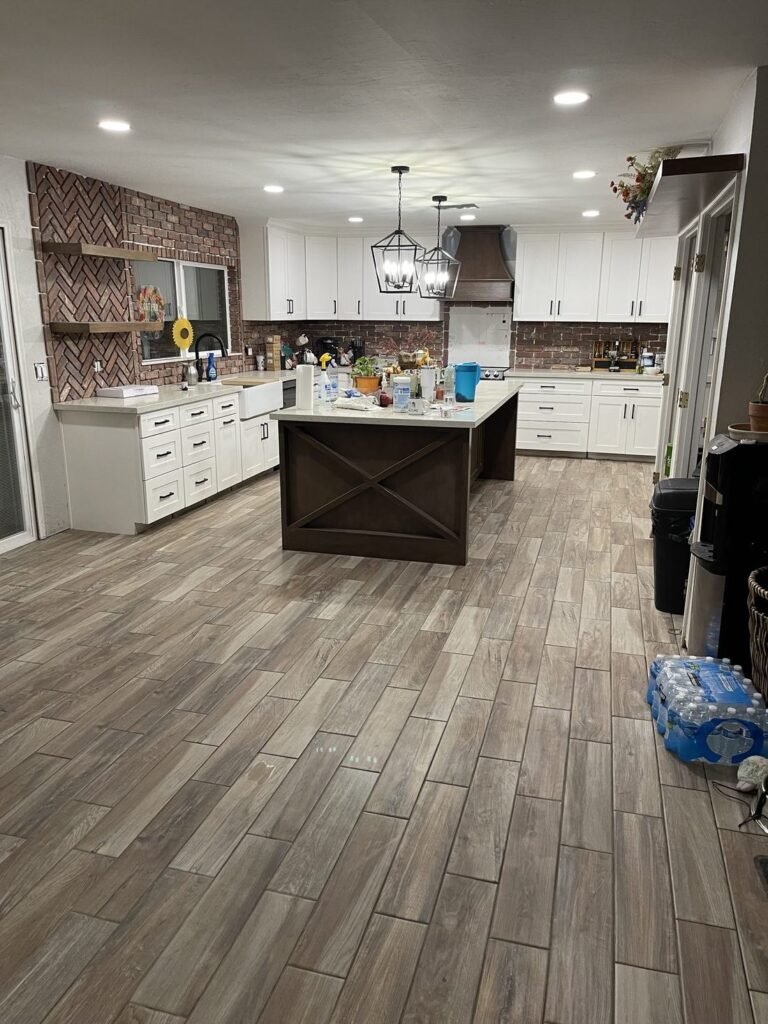 Kitchen with white shaker cabinets, quartz counters and a dark wood island